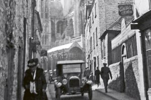 Vintage Motor Car passing old Cycle Shop in Truro 19023